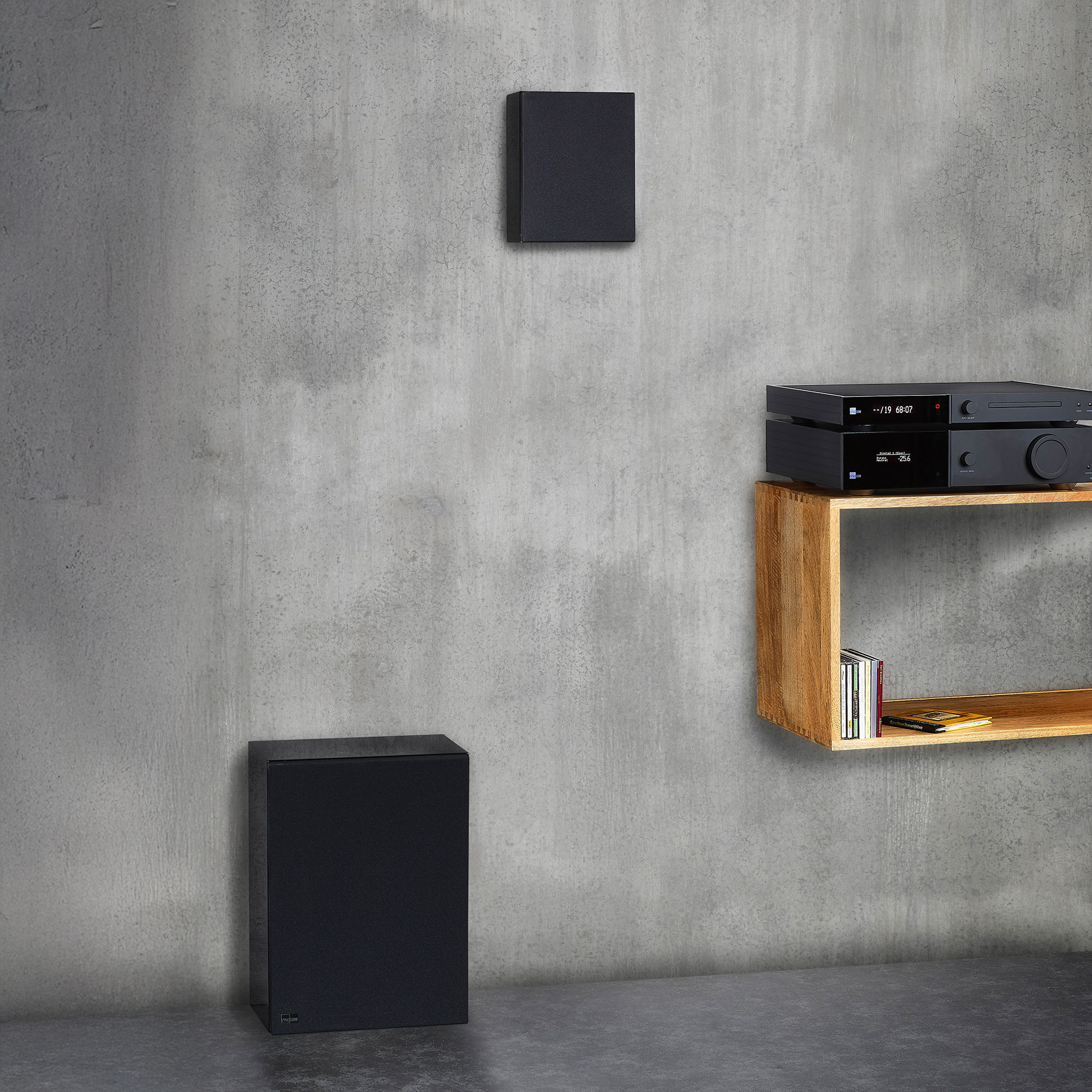 Lyngdorf BW-2 Subwoofer schwarz und MH-2 schwarz mit Abdeckungen Bildformat 2000x2000 grauer Wand